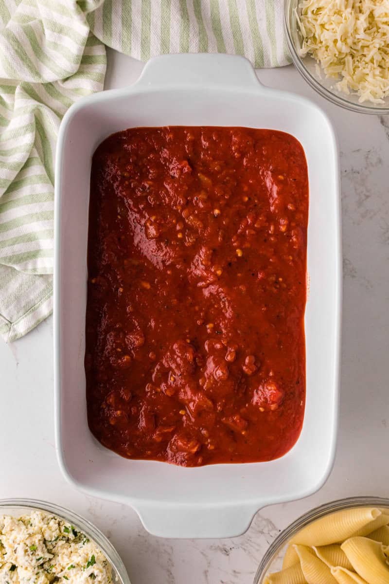 spaghetti sauce on the bottom of the baking dish.