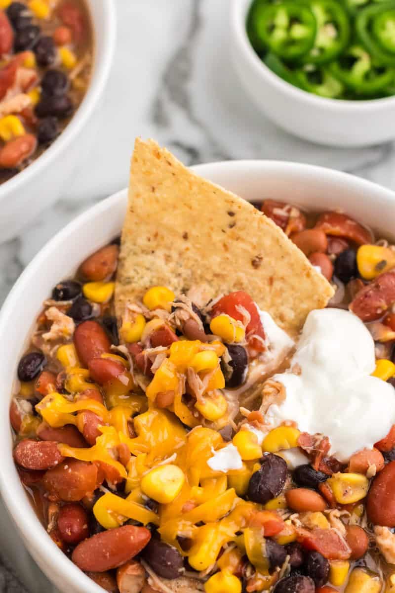 scooping out some of the taco soup with a tortilla chip.
