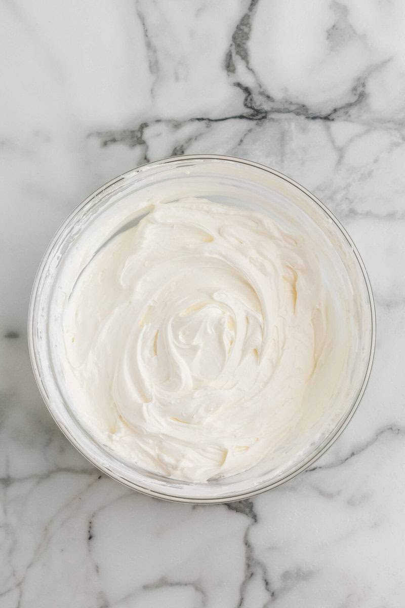 bowl of the cream cheese mixed with the whipped topping.
