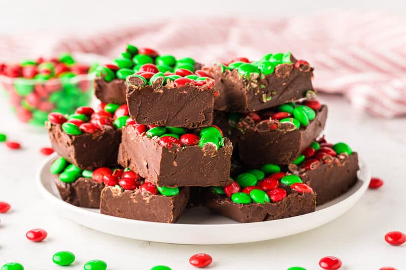 Christmas Fudge stacked on top of each other on a white plate.
