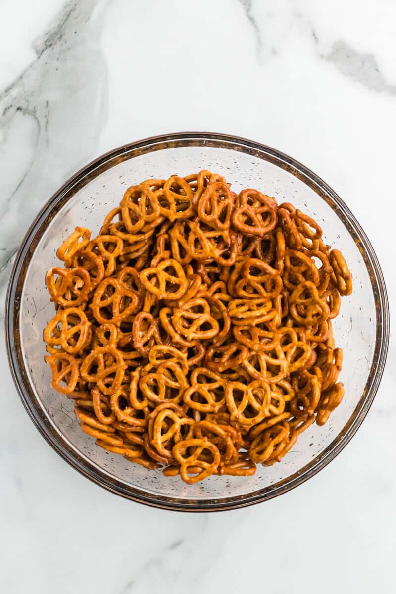 pretzels in a mixing bowl tossed in oil.
