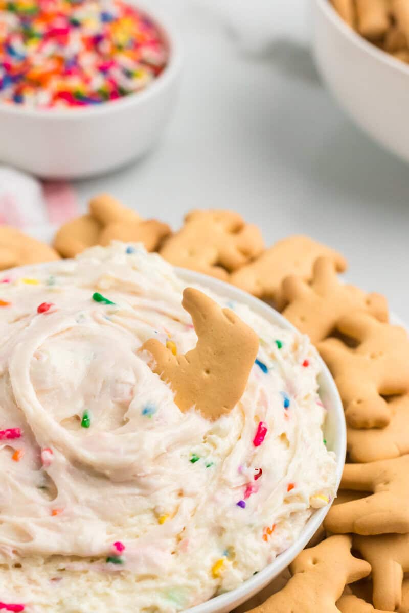 closeup of an animal cracker dipped into the Funfetti Dip.