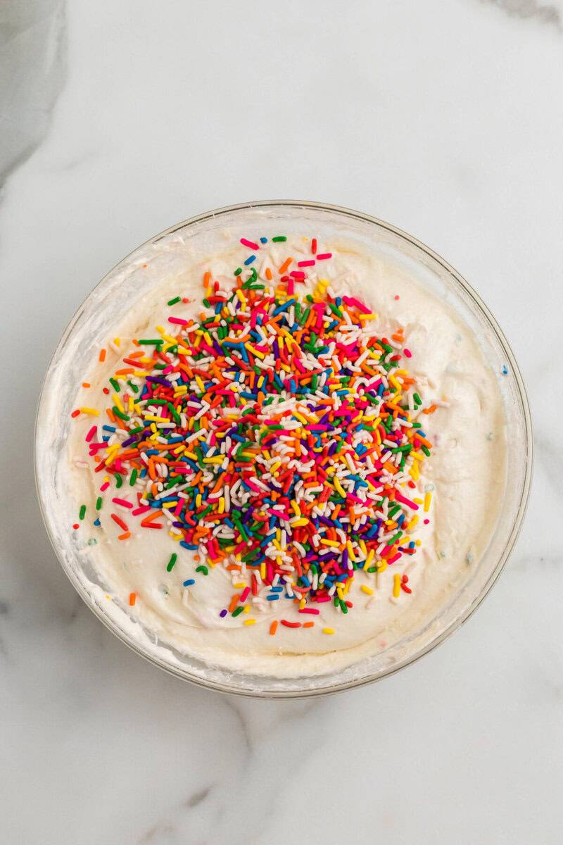 adding in the cake mix and sprinkles.