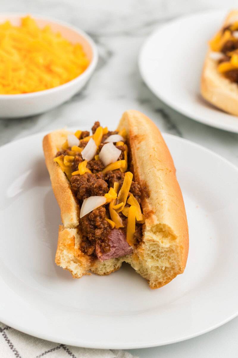 Hot Dog with Chili on top with a bit taken out of it.