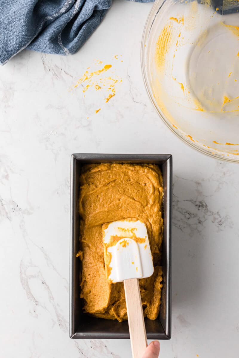spreading the bread batter into a bread pan.