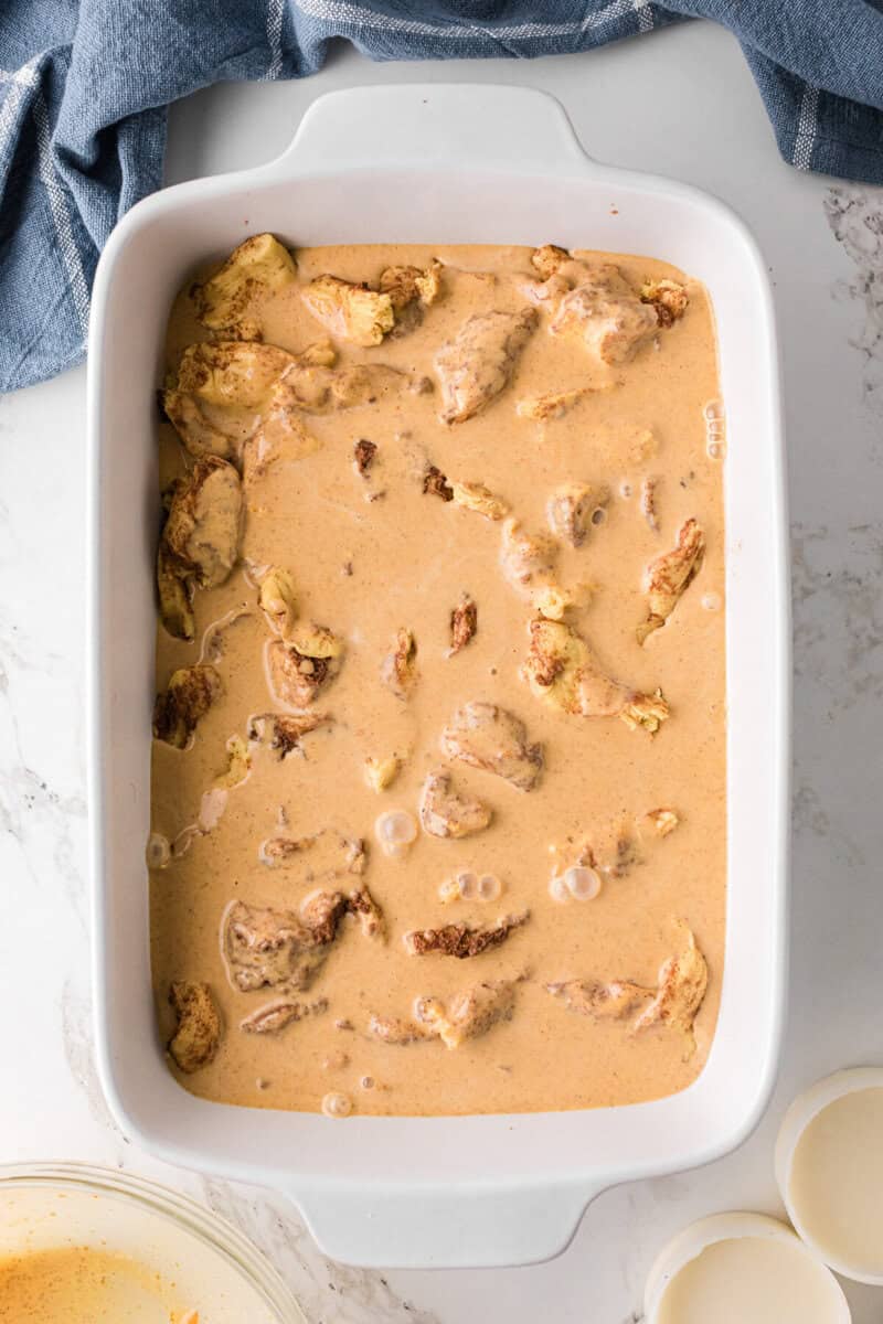 the pumpkin mixture poured over the cinnamon roll casserole.