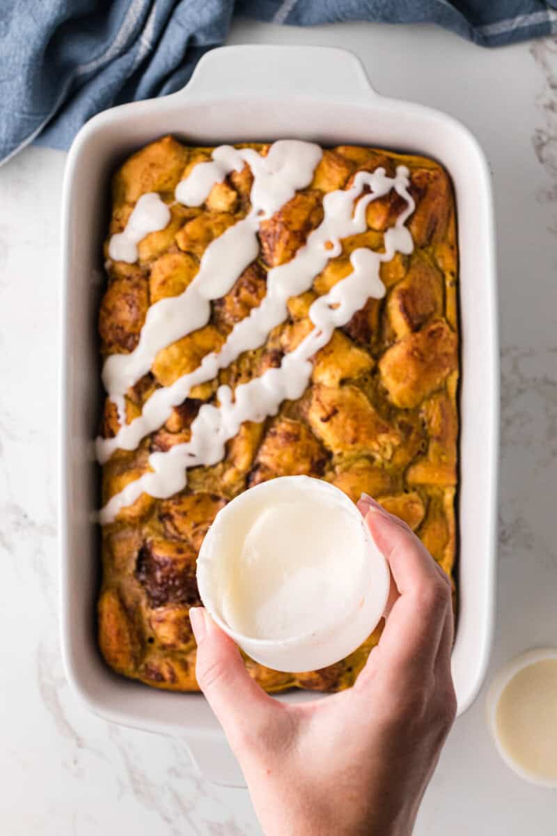 pouring the icing over the casserole.