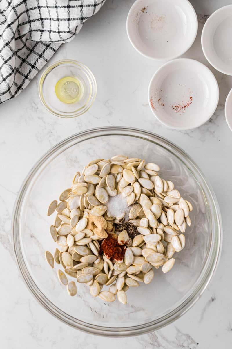 pumpkin seeds in a bowl with seasoning.