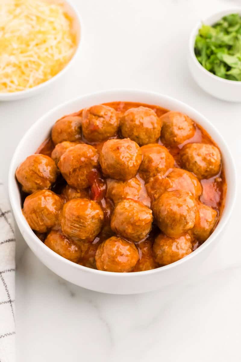 closeup of the slow cooker enchilada meatballs served in a white bowl.