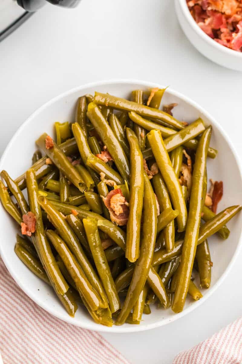 top-down closeup of the green beans served on a white plate.