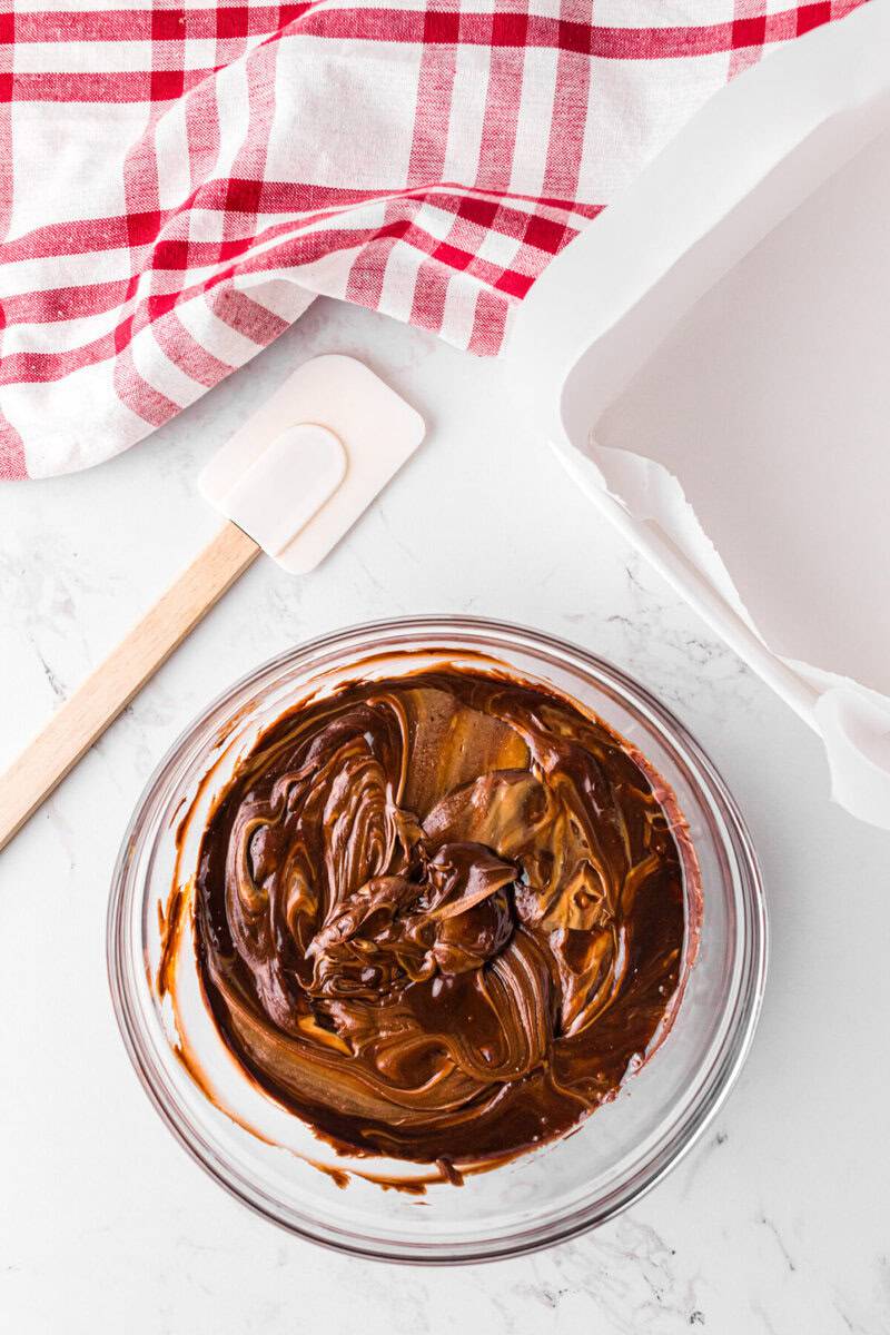 melted frosting and peanut butter mixed together in large glass bowl.