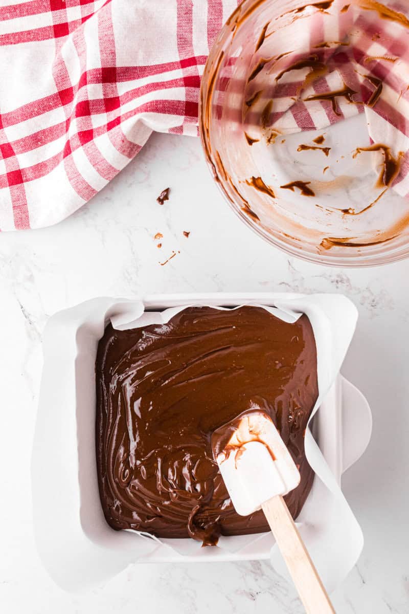spreading the peanut butter and frosting mixture into the cooling dish.