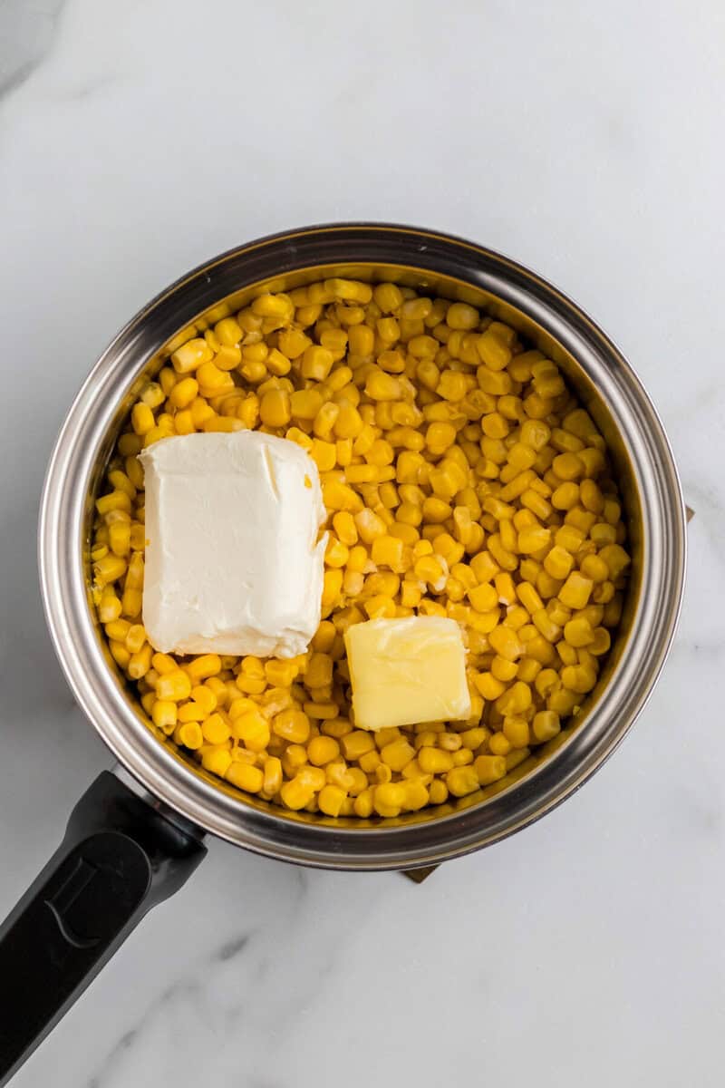 corn, butter and cream cheese in a pot.