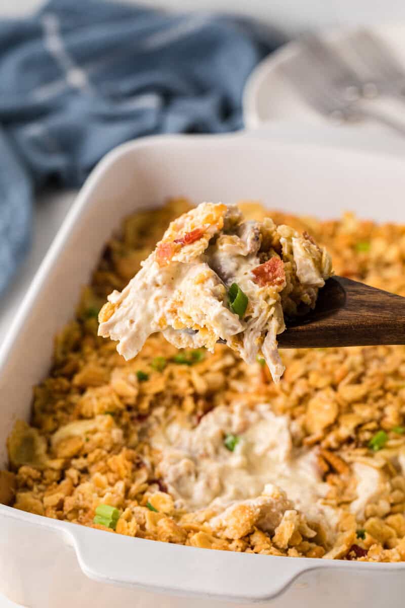 serving the casserole with a wooden spoon.