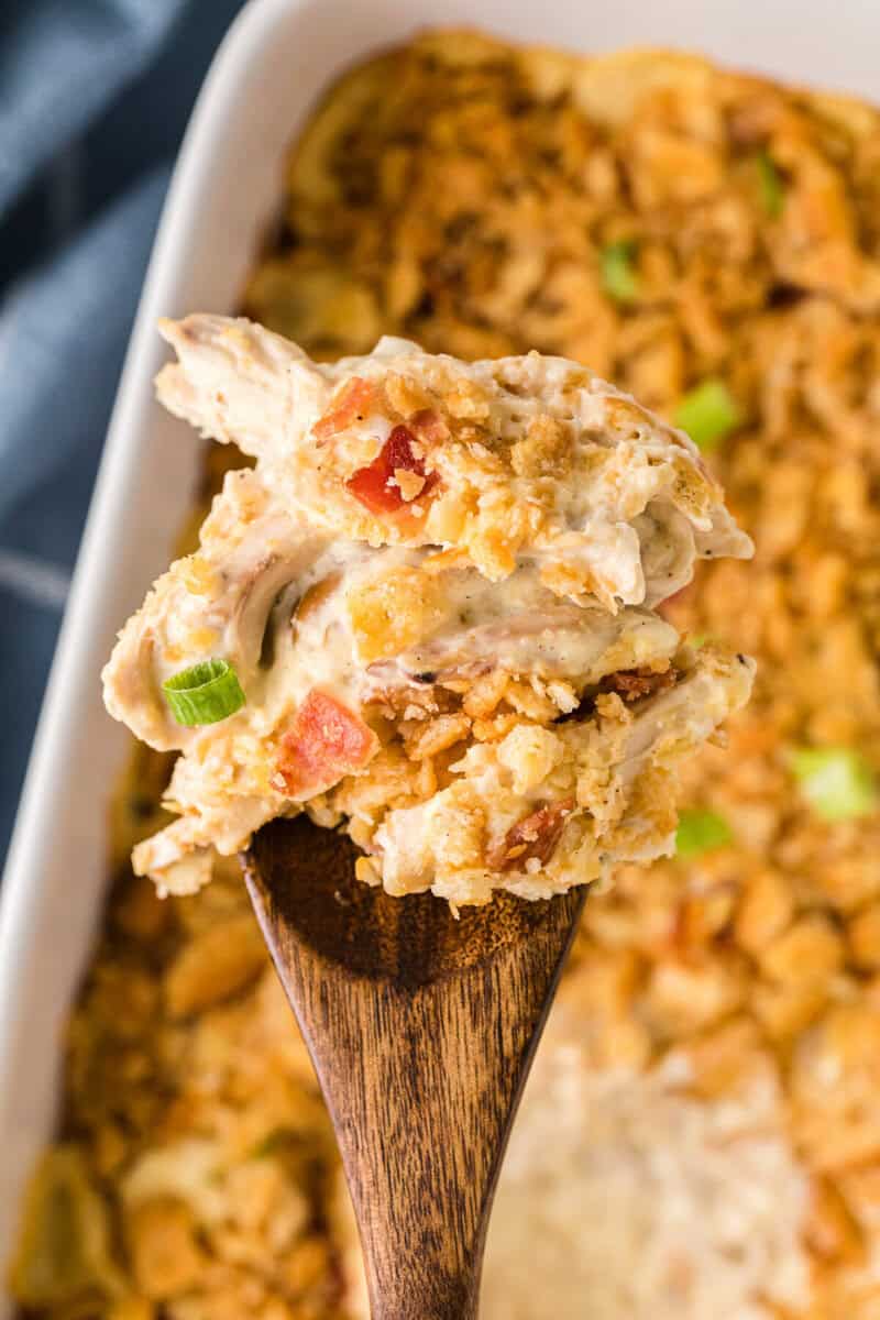 closeup of the Million Dollar Chicken Casserole served on a wooden spoon.