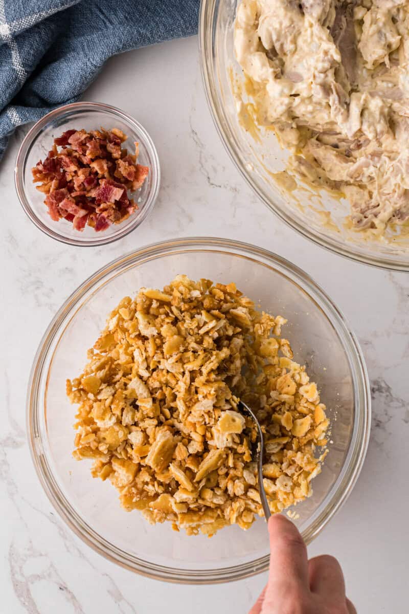crushing Ritz crackers in a glass bowl for the topping.