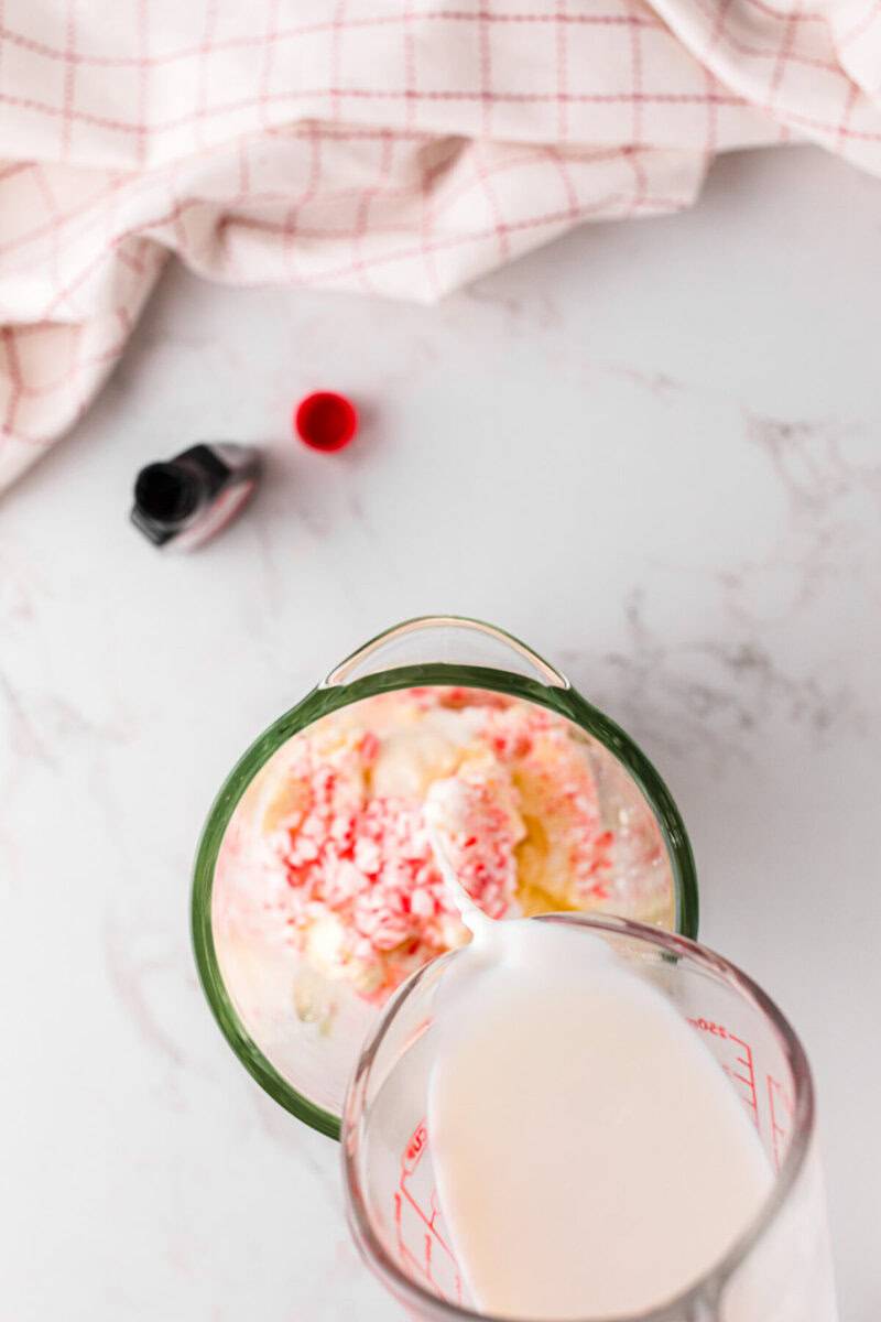 pouring the milk into the blender for the milkshake.