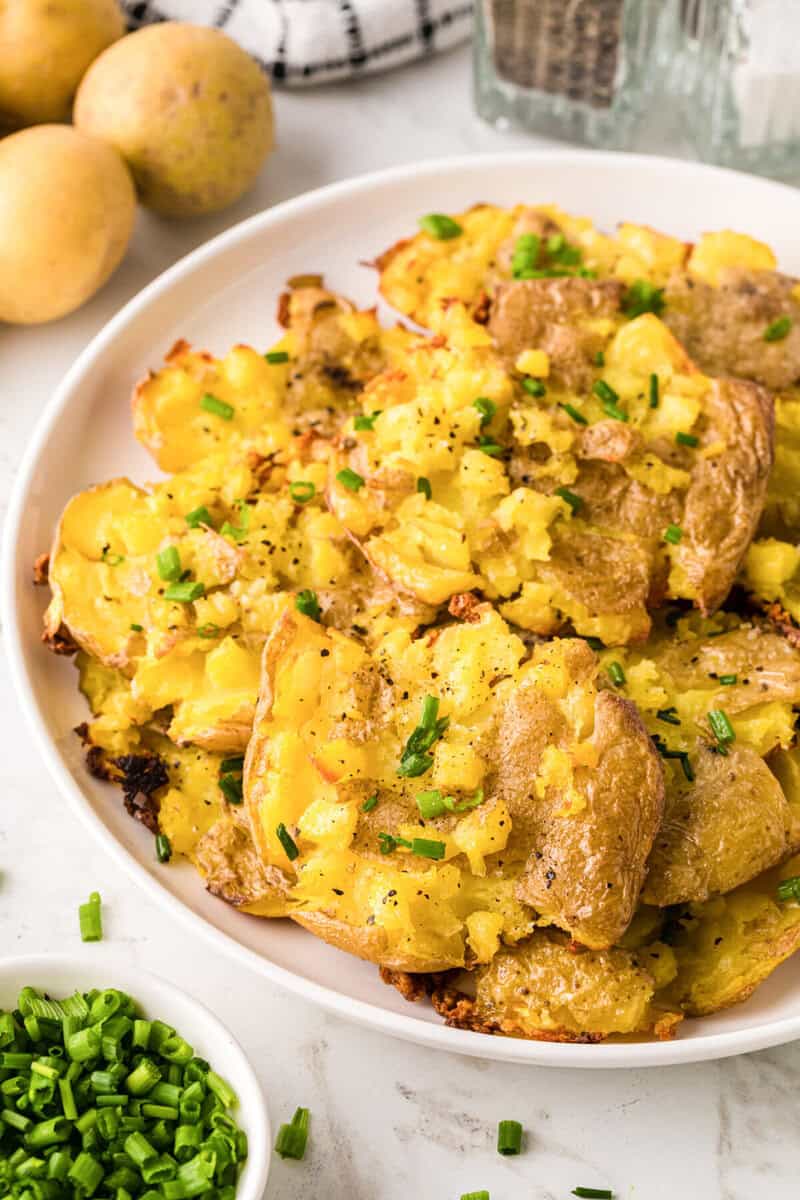 the smashed potatoes served on a white plate.