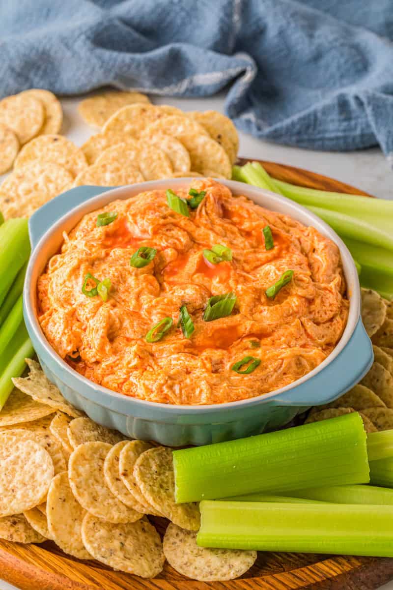 bowl of the Buffalo Chicken Dip with tortilla chips and celery sticks around it.