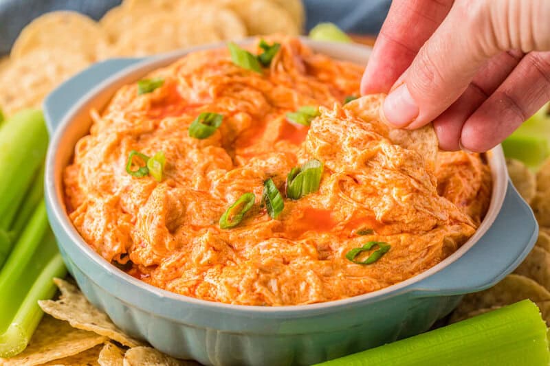 dipping a tortilla chip into the Buffalo Chicken Dip.