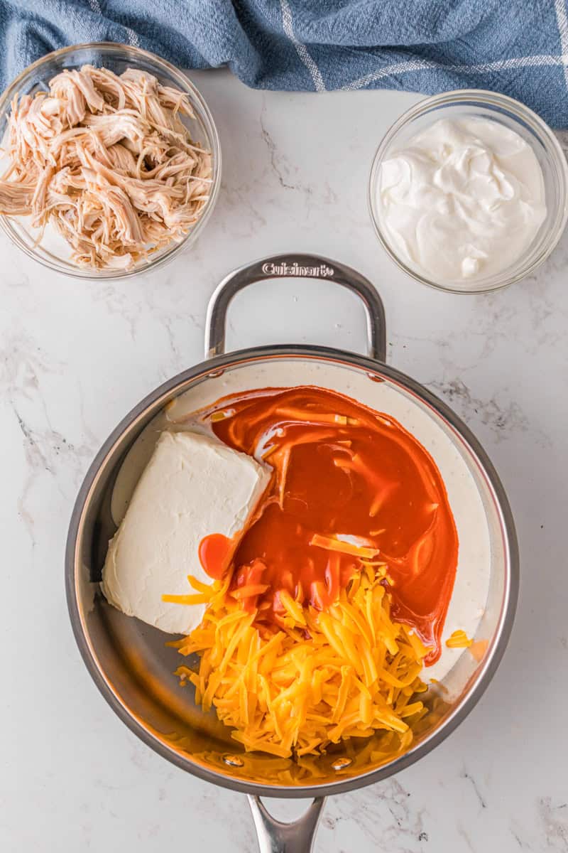 mixing the ingredients together to make the Buffalo Sauce to make the dip in the pan.