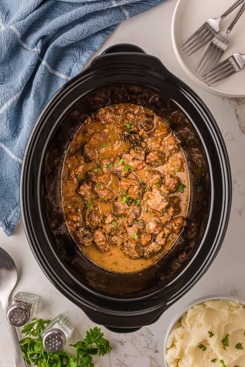 top-down view of the beef tips in the slow cooker.