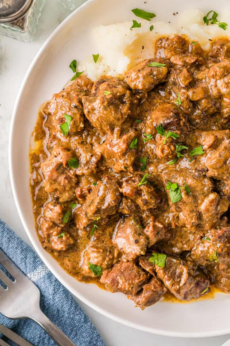 closeup of the beef tips served on a white plate.
