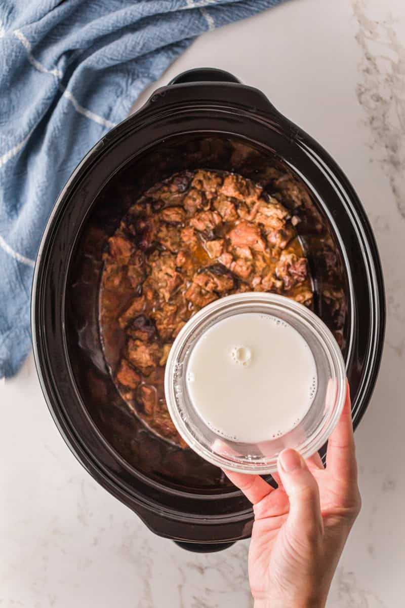 pouring the cornstarch mixture into the beef tips in the slow cooker.