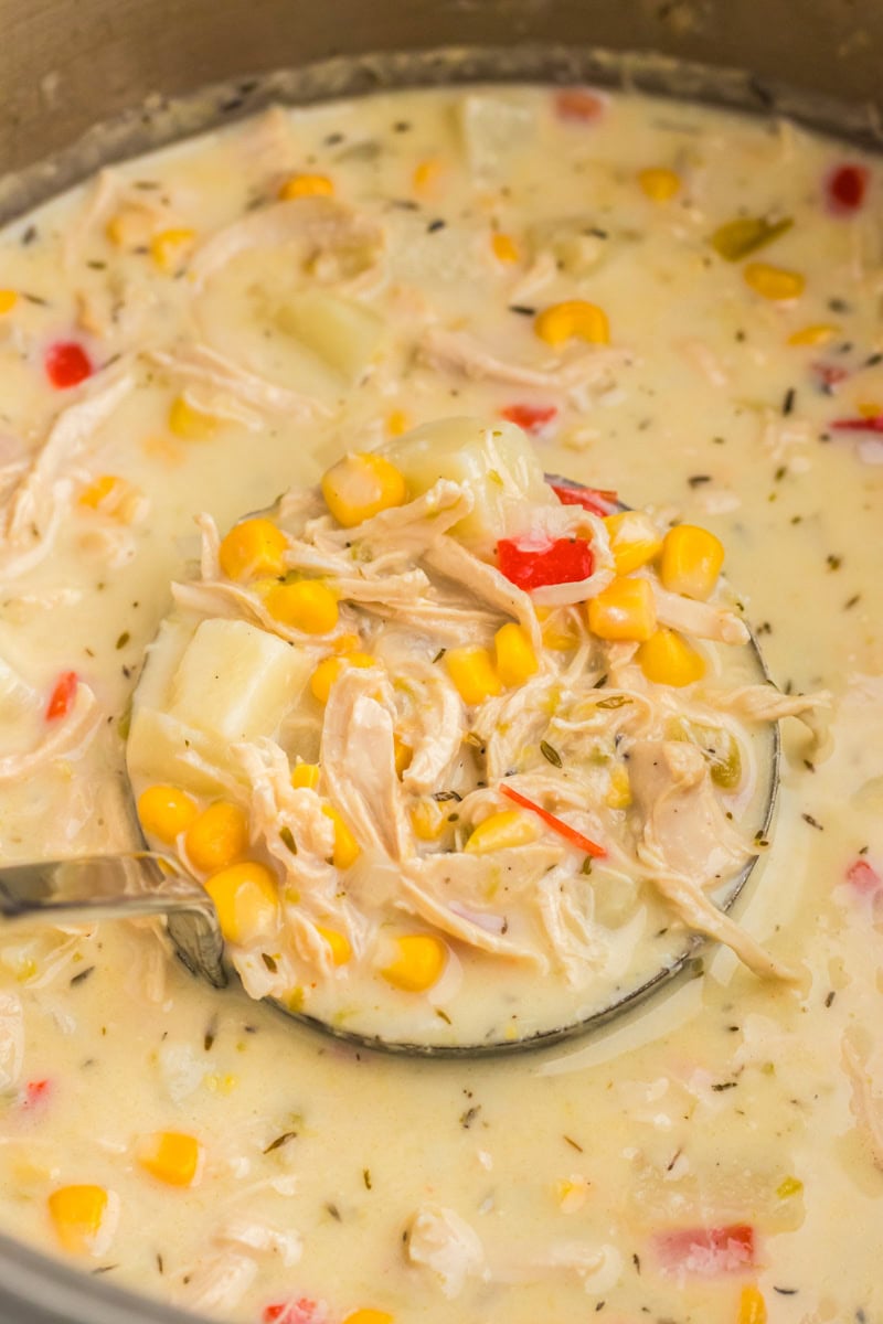closeup of serving the chicken corn chowder with a ladle.
