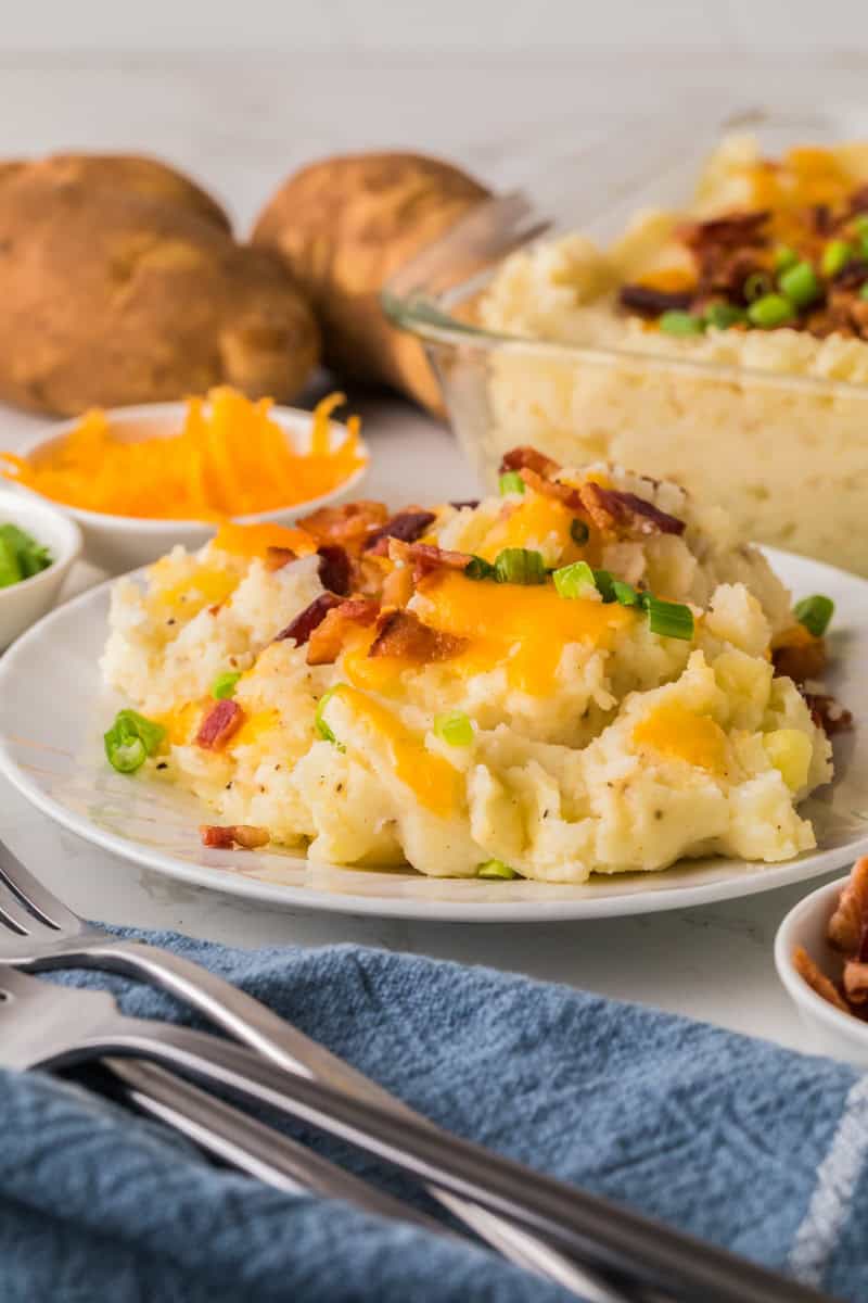 loaded mashed potatoes served on a white plate.