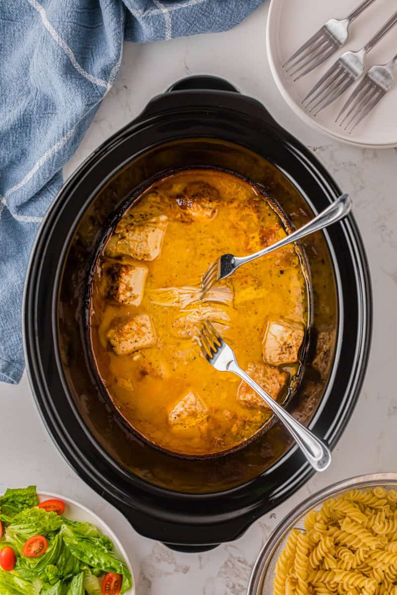 shredding the chicken in the slow cooker.