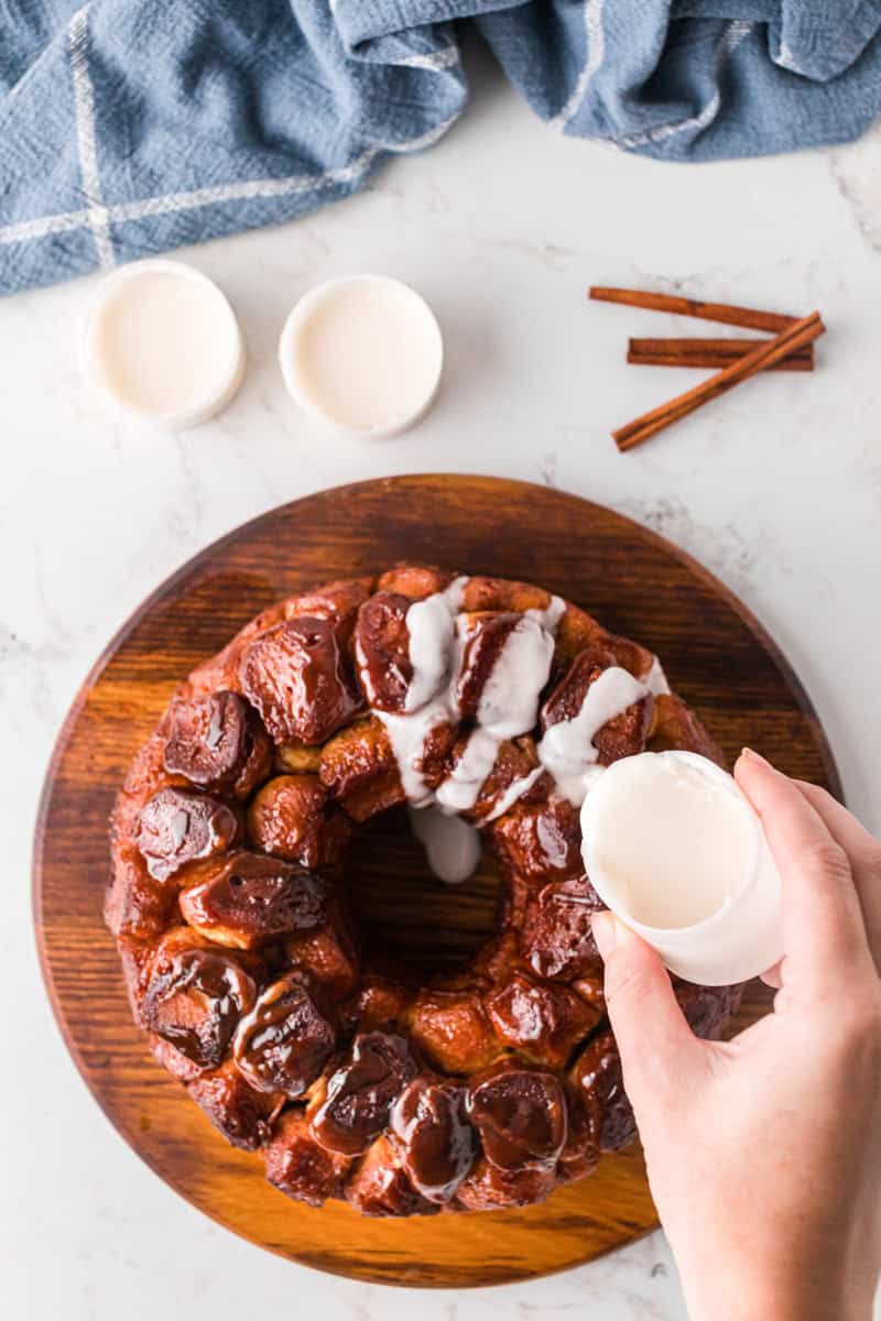 drizzling the icing on the baked monkey bread.