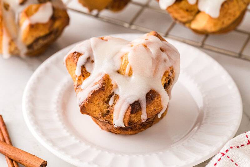 cinnamon roll muffin served on a white plate.
