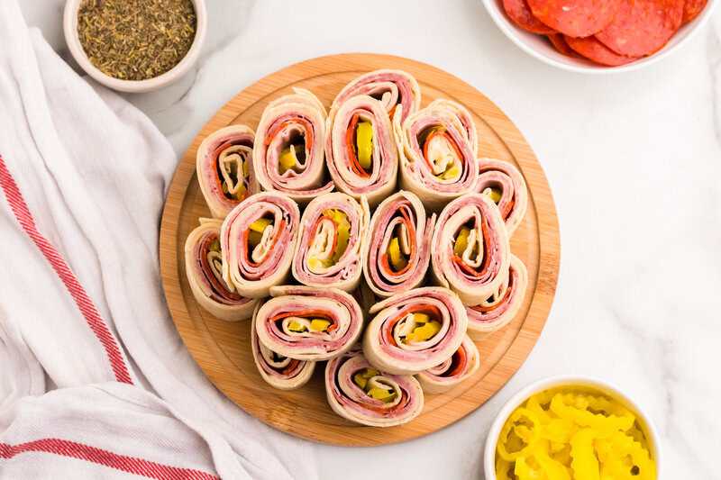 Italian Pinwheels served on a wooden serving tray.