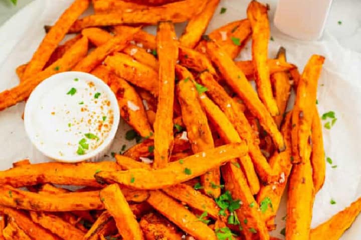 Air fryer Sweet Potato Fries served with Ranch on a white plate.