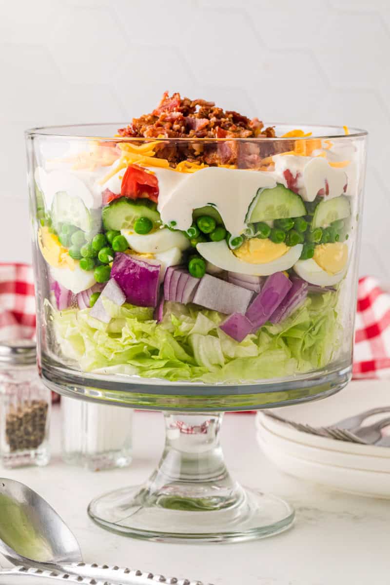closeup of the 7 Layer Salad served in a glass trifle dish.
