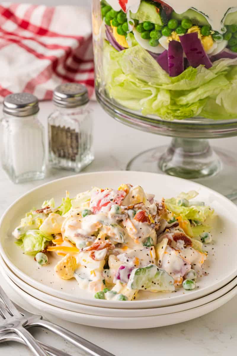serving the salad on a white plate.