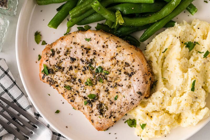 top-down view of the pork chops served on a white plate.