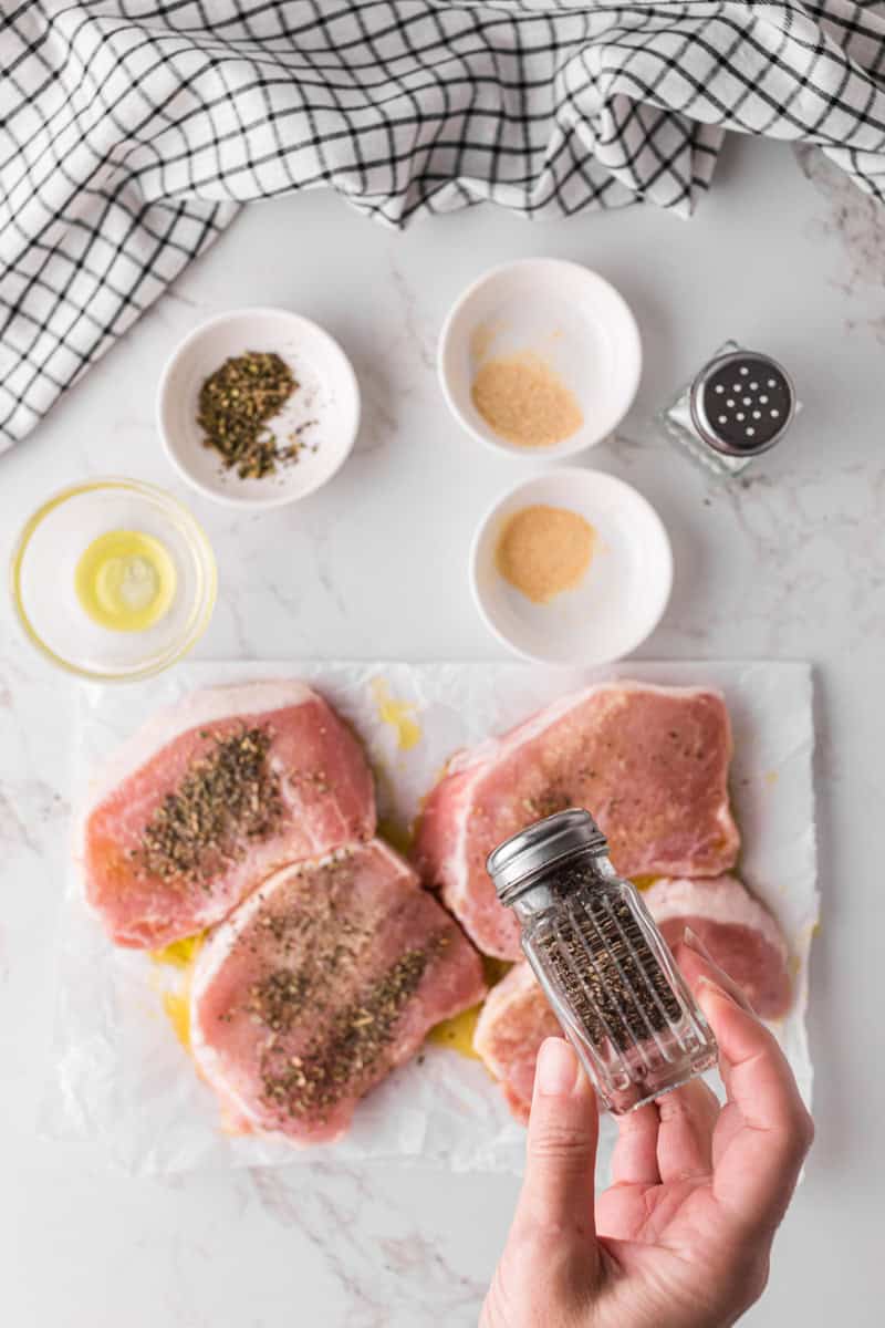 seasoning the pork chops.