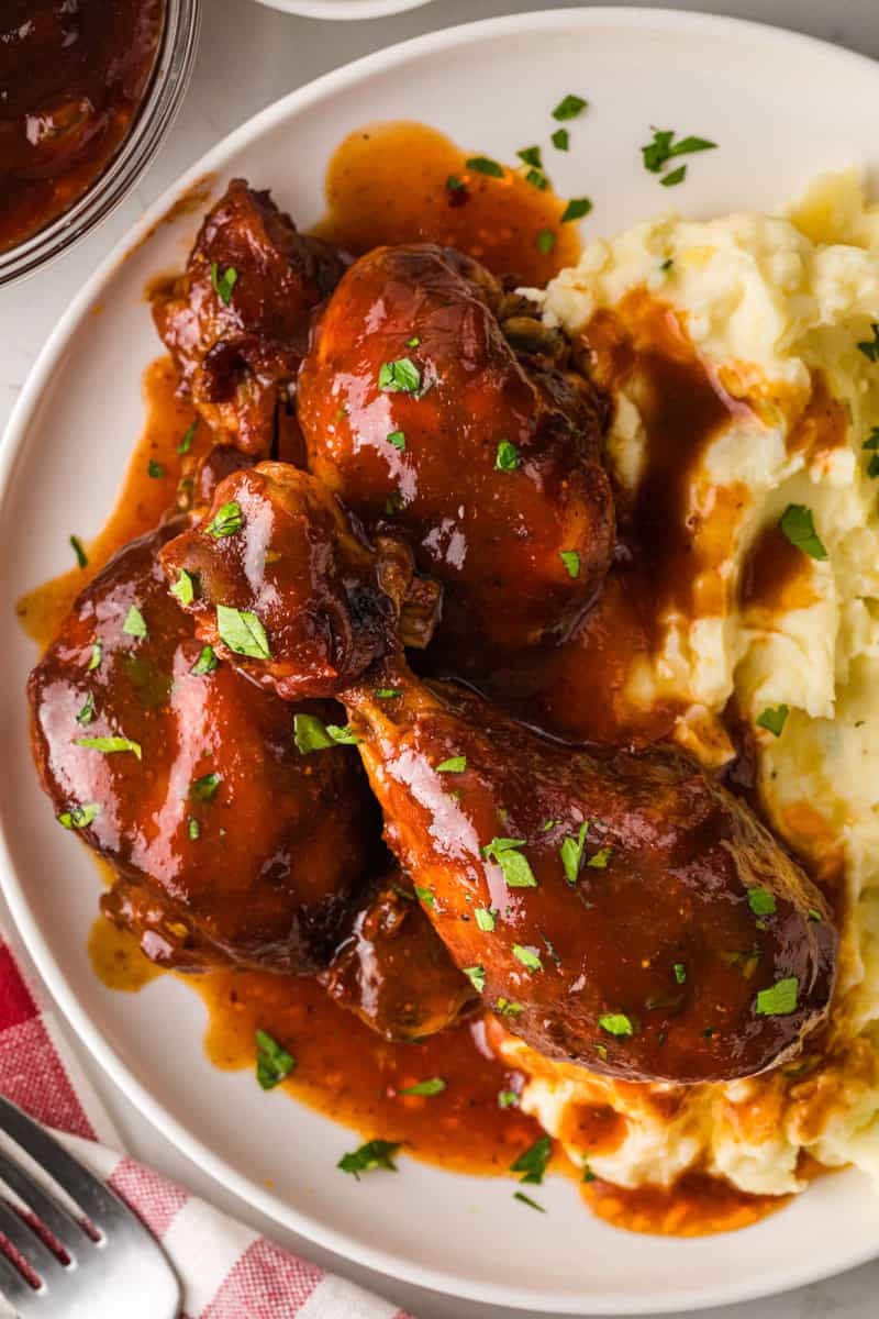 BBQ Chicken Legs served on a bed of mashed potatoes.