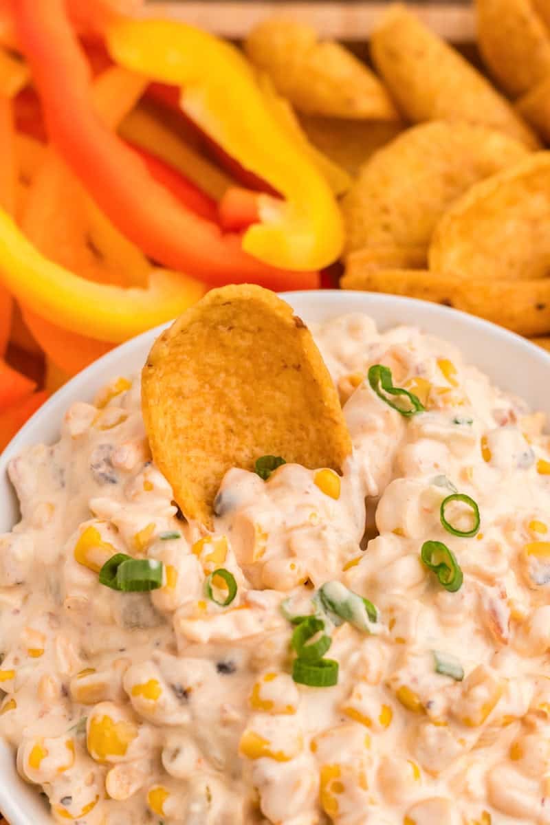 using a corn chip to dip in the Crack Corn Dip.