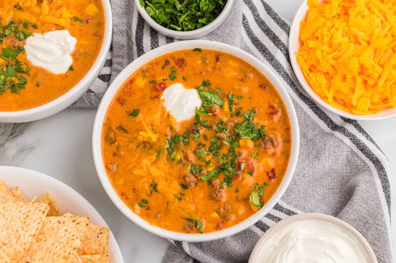 top-down view of the Beef Nacho Soup served in white bowls.