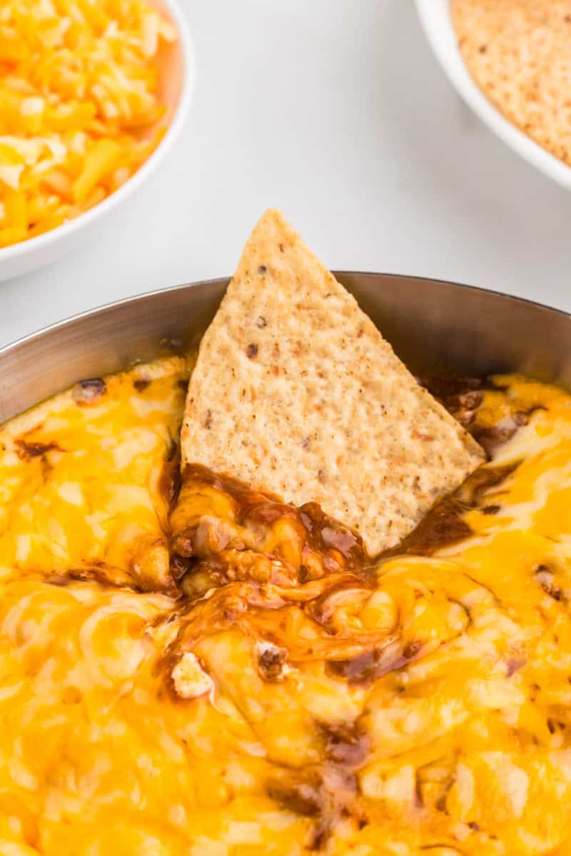 closeup of a chip dipped in the Chili Cheese Dip.