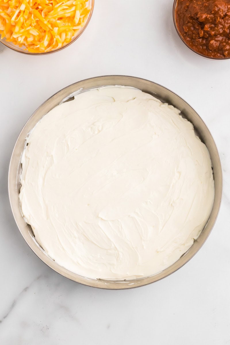 Cream Cheese spread on the bottom of a pie dish.