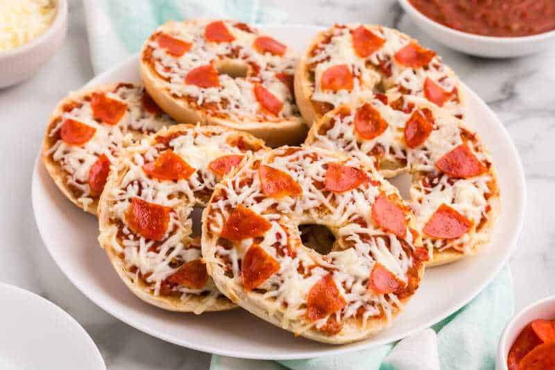 Pizza bagels served on a white plate.