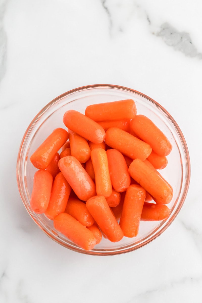washed baby carrots in a clear bowl.
