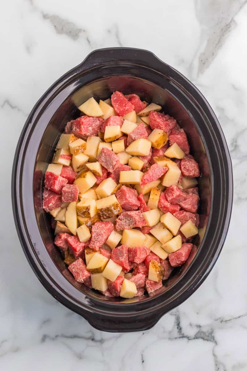 top-down view of the steak and potatoes in the slow cooker.