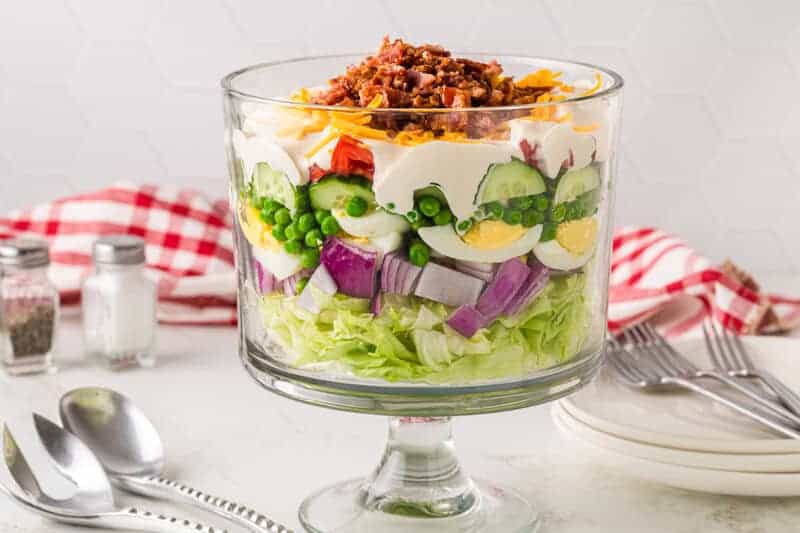 7-Layer Salad served in a glass trifle dish.
