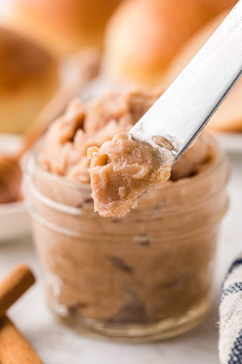 using a knife to spread the honey butter.