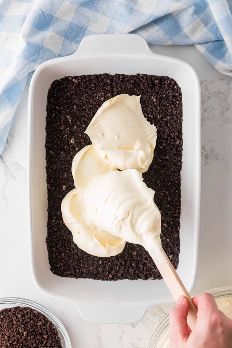spreading the pudding mixture over the Oreo crust.